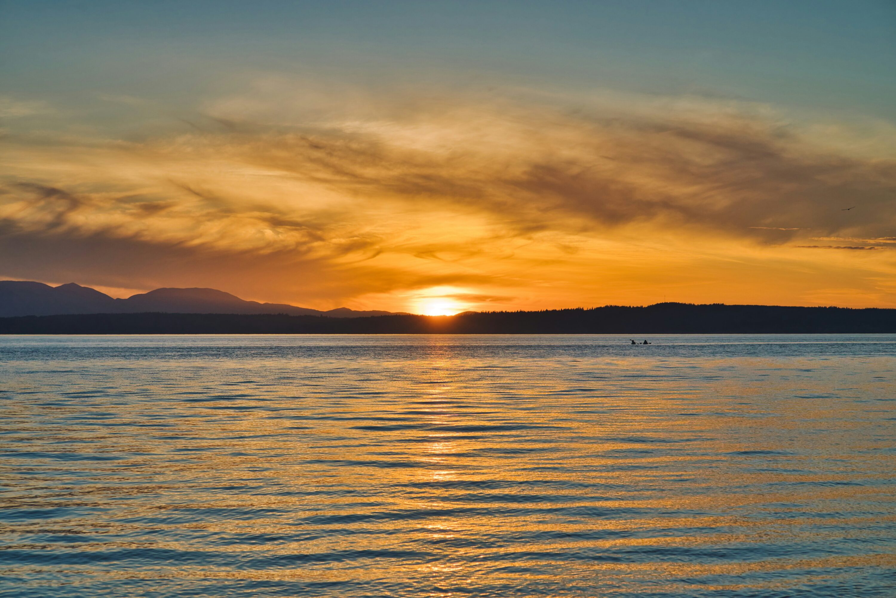 Sunset over the water with mountains in the distance, coming this year to Chapel Hill
